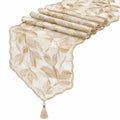 Chemin de table en dentelle dorée avec motifs de feuilles et pompon